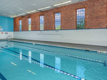 a swimming pool with a brick wall and windows at Bigelow Commons, Enfield, Connecticut
